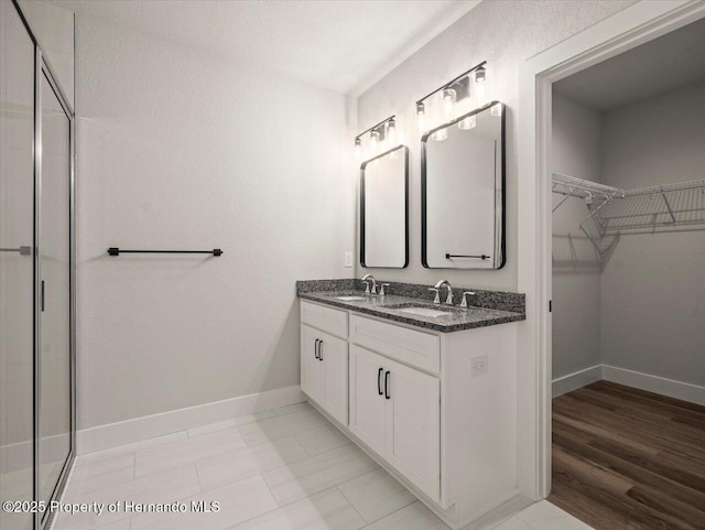 14448 Chimney Swift Rd, Weeki Wachee, FL 34614 - full bath featuring a spacious closet, double vanity, baseboards, and a shower with shower door
