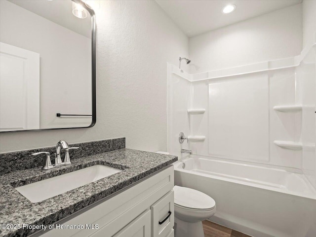 14448 Chimney Swift Rd, Weeki Wachee, FL 34614 - full bath featuring vanity, toilet, shower / tub combination, wood finished floors, and a textured wall