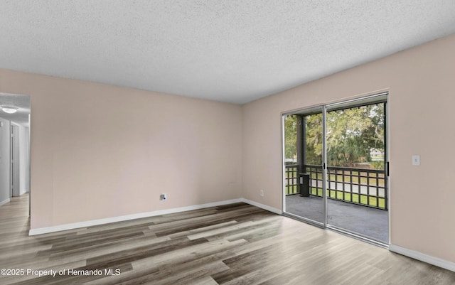 6519 W Newberry Rd Unit 107, Gainesville, FL 32605 - empty room with wood finished floors, baseboards, and a textured ceiling