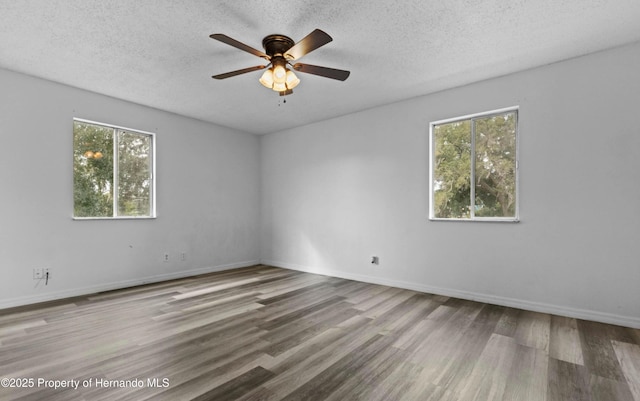 6519 W Newberry Rd Unit 107, Gainesville, FL 32605 - empty room with wood finished floors, ceiling fan, a textured ceiling, and baseboards