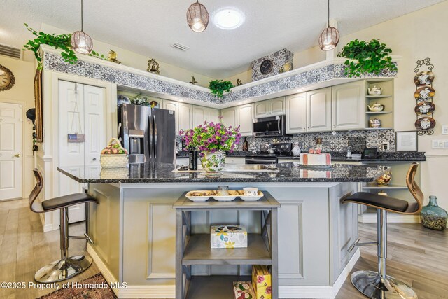 18223 Nestlebranch Ct, Hudson, FL 34667 - kitchen with stainless steel appliances, open shelves, light wood-style floors, a kitchen bar, and decorative backsplash