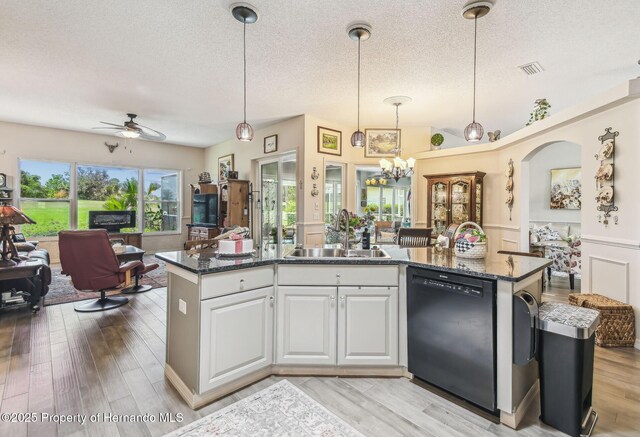 18223 Nestlebranch Ct, Hudson, FL 34667 - kitchen featuring dishwasher, a sink, open floor plan, a textured ceiling, and light wood-style floors
