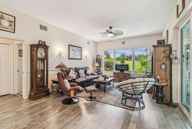 18223 Nestlebranch Ct, Hudson, FL 34667 - living area featuring ceiling fan, light wood-type flooring, and a textured ceiling