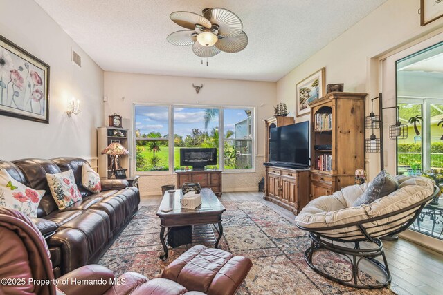 18223 Nestlebranch Ct, Hudson, FL 34667 - living room with a ceiling fan, light wood-type flooring, and a textured ceiling