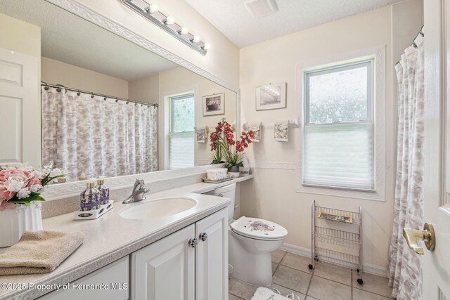18223 Nestlebranch Ct, Hudson, FL 34667 - bathroom with toilet, vanity, tile patterned floors, baseboards, and a textured ceiling
