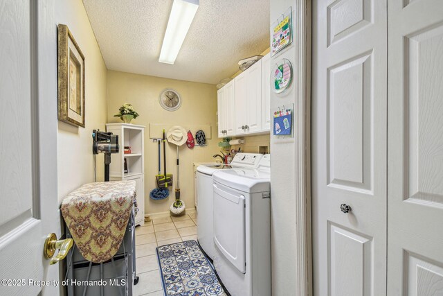 18223 Nestlebranch Ct, Hudson, FL 34667 - washroom with cabinet space, washing machine and clothes dryer, light tile patterned floors, and a textured ceiling