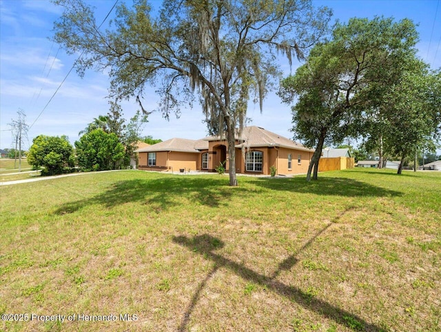 12167 Bath St, Spring Hill, FL 34609 - ranch-style house with a front yard, a garage, and stucco siding