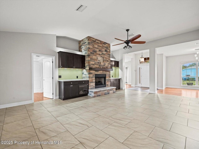 12167 Bath St, Spring Hill, FL 34609 - unfurnished living room with a ceiling fan, a stone fireplace, lofted ceiling, and baseboards
