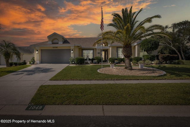 1049 Larkin Rd, Spring Hill, FL 34608 - single story home featuring a lawn, a garage, driveway, and stucco siding