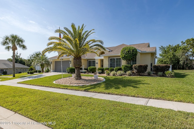 1049 Larkin Rd, Spring Hill, FL 34608 - view of front facade with stucco siding, concrete driveway, a front lawn, and an attached garage