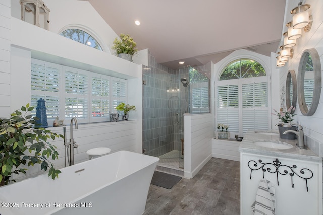 1049 Larkin Rd, Spring Hill, FL 34608 - full bath with healthy amount of natural light, a shower stall, wood finished floors, double vanity, and vaulted ceiling