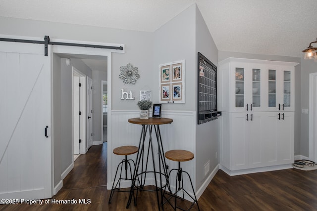 1049 Larkin Rd, Spring Hill, FL 34608 - entryway with dark wood finished floors, wainscoting, a textured ceiling, and a barn door