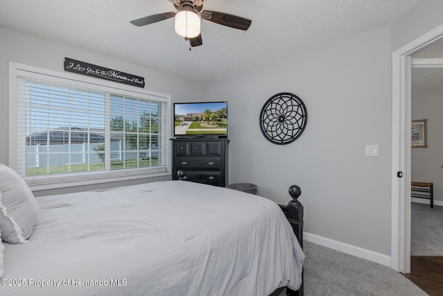 1049 Larkin Rd, Spring Hill, FL 34608 - bedroom featuring a textured ceiling, baseboards, ceiling fan, and carpet flooring