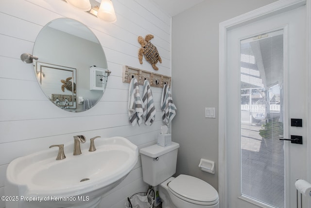 1049 Larkin Rd, Spring Hill, FL 34608 - bathroom with a sink, toilet, and wood walls