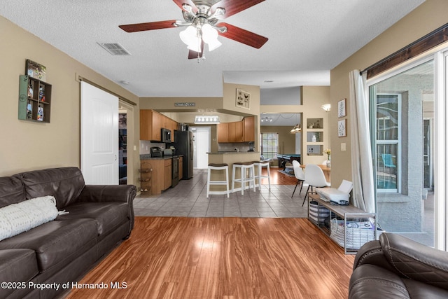 14031 Hexam Rd, Brooksville, FL 34613 - living area featuring wood finished floors, a ceiling fan, and a textured ceiling