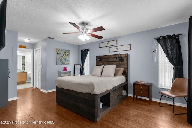 14031 Hexam Rd, Brooksville, FL 34613 - bedroom featuring wood finished floors, baseboards, a closet, a textured ceiling, and ensuite bath