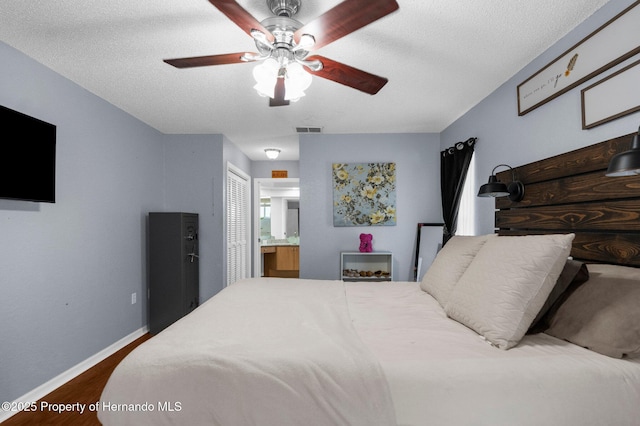 14031 Hexam Rd, Brooksville, FL 34613 - bedroom featuring dark wood finished floors, baseboards, ensuite bathroom, a textured ceiling, and a closet