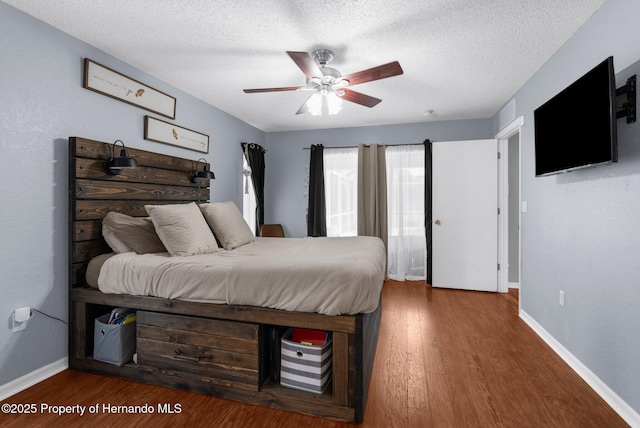 14031 Hexam Rd, Brooksville, FL 34613 - bedroom with baseboards, wood finished floors, a textured ceiling, and ceiling fan