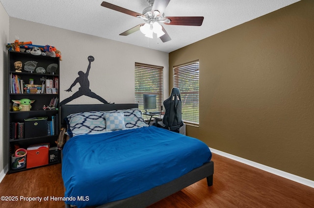 14031 Hexam Rd, Brooksville, FL 34613 - bedroom with wood finished floors, baseboards, a textured ceiling, and ceiling fan
