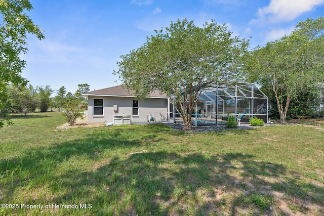 14031 Hexam Rd, Brooksville, FL 34613 - back of house with a lawn, an outdoor pool, a lanai, and stucco siding