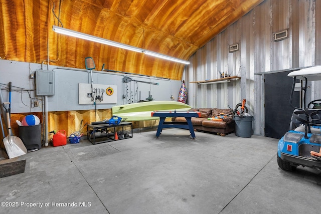 14031 Hexam Rd, Brooksville, FL 34613 - garage with electric panel, wood walls, and wood ceiling