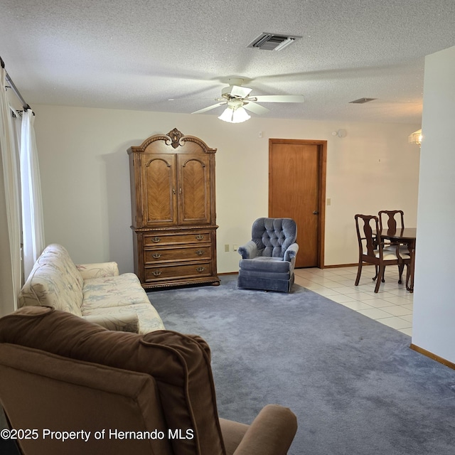2226 Giralda Ave, Spring Hill, FL 34606 - living room with light carpet, ceiling fan, a textured ceiling, light tile patterned floors, and baseboards