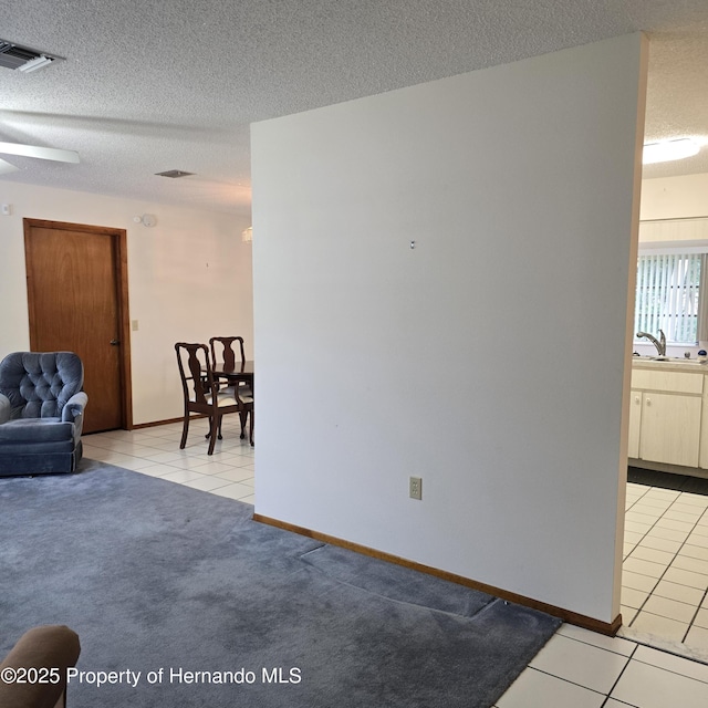 2226 Giralda Ave, Spring Hill, FL 34606 - living area featuring light tile patterned floors, a textured ceiling, and baseboards