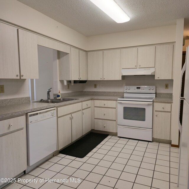 2226 Giralda Ave, Spring Hill, FL 34606 - kitchen featuring white appliances, under cabinet range hood, a sink, a textured ceiling, and light countertops