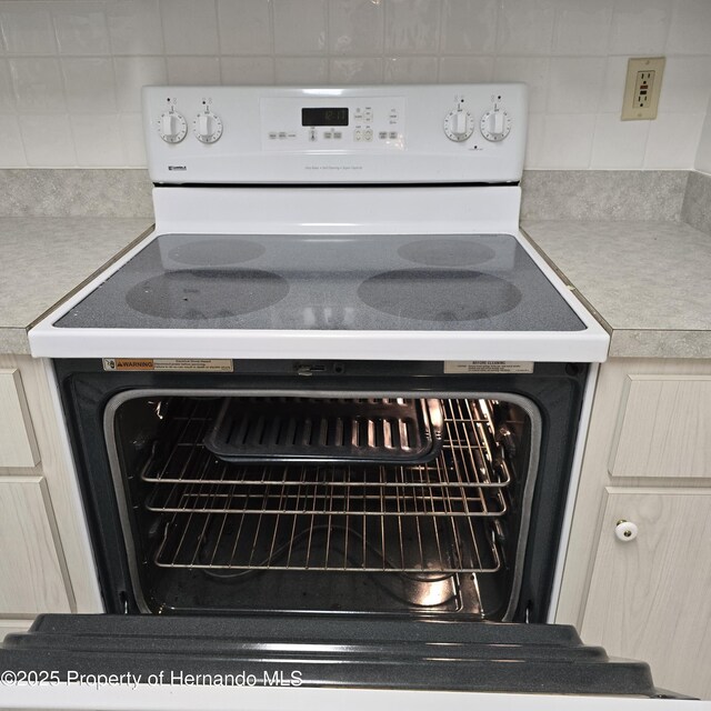 2226 Giralda Ave, Spring Hill, FL 34606 - kitchen view of electric range, backsplash, and light countertops