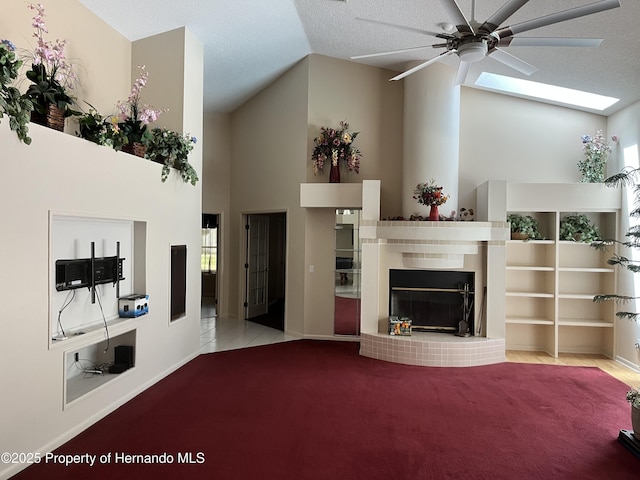 24 Black Willow Ct N, Homosassa, FL 34446 - carpeted living area featuring a ceiling fan, a tiled fireplace, high vaulted ceiling, and baseboards