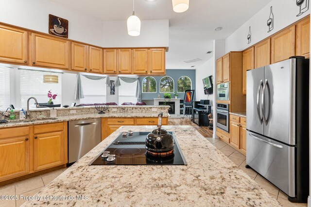 5182 Championship Cup Ln, Spring Hill, FL 34609 - kitchen with appliances with stainless steel finishes, light tile patterned floors, a sink, and light stone counters