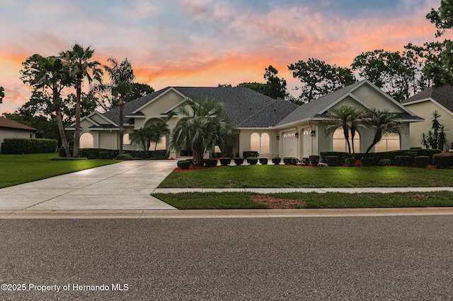 5182 Championship Cup Ln, Spring Hill, FL 34609 - view of front of property with concrete driveway, a garage, a yard, and stucco siding
