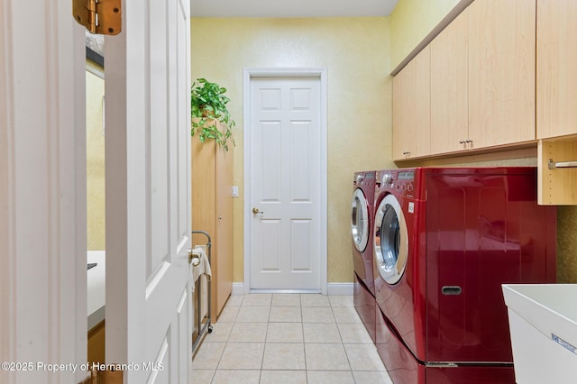 5182 Championship Cup Ln, Spring Hill, FL 34609 - laundry room featuring washer and clothes dryer, cabinet space, light tile patterned flooring, and baseboards