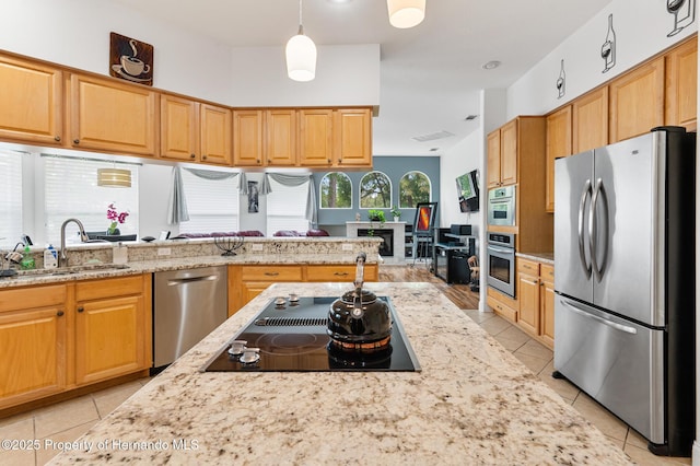 5182 Championship Cup Ln, Spring Hill, FL 34609 - kitchen featuring stainless steel appliances, light tile patterned flooring, a sink, light stone countertops, and pendant lighting