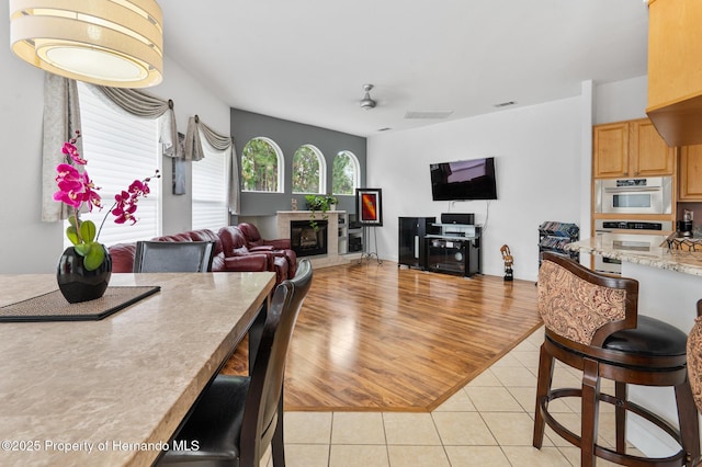 5182 Championship Cup Ln, Spring Hill, FL 34609 - living area featuring a glass covered fireplace, light tile patterned floors, and ceiling fan