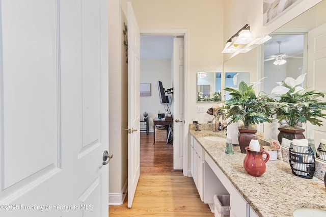 5182 Championship Cup Ln, Spring Hill, FL 34609 - bathroom featuring double vanity, wood finished floors, and a ceiling fan