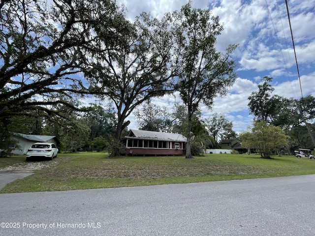 15306 Spokane Rd, Spring Hill Pasco, FL 34610 - view of front of home featuring a front lawn, metal roof, and driveway
