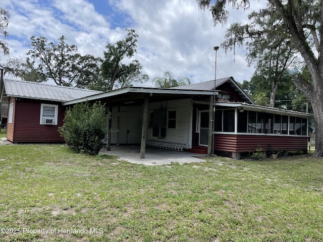 15306 Spokane Rd, Spring Hill Pasco, FL 34610 - rear view of property with a sunroom, metal roof, a yard, and a carport