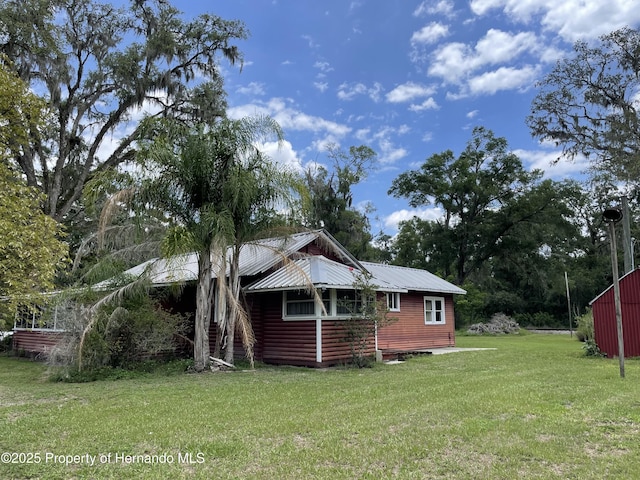 15306 Spokane Rd, Spring Hill Pasco, FL 34610 - view of home's exterior with a lawn and metal roof