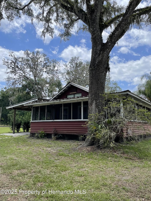 15306 Spokane Rd, Spring Hill Pasco, FL 34610 - view of front of property with a sunroom, a front yard, and an attached carport