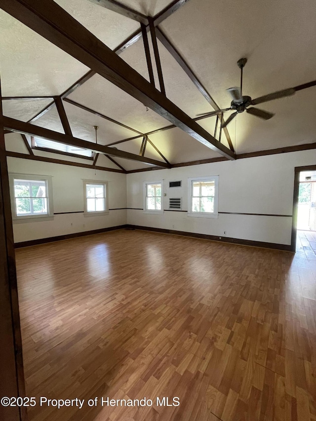 15306 Spokane Rd, Spring Hill Pasco, FL 34610 - empty room featuring baseboards, wood finished floors, ceiling fan, healthy amount of natural light, and beamed ceiling