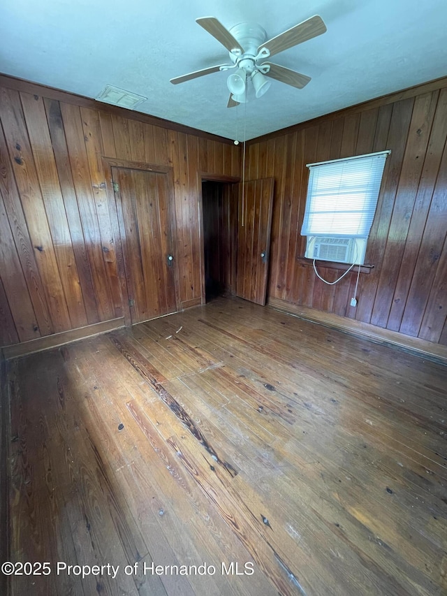 15306 Spokane Rd, Spring Hill Pasco, FL 34610 - unfurnished bedroom with hardwood / wood-style flooring, wooden walls, and cooling unit