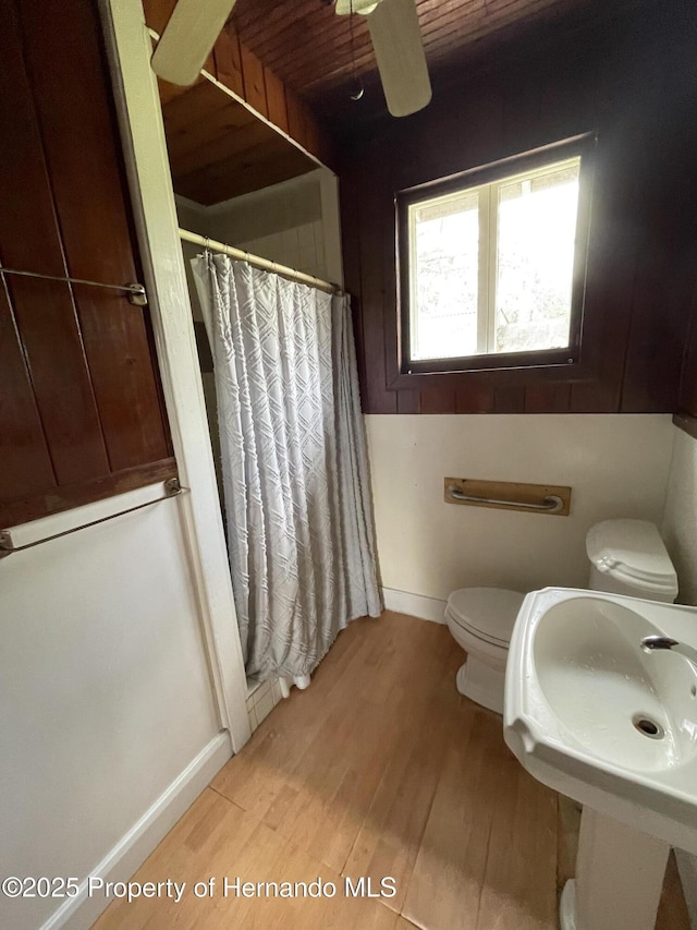 15306 Spokane Rd, Spring Hill Pasco, FL 34610 - bathroom featuring wood finished floors, a shower stall, toilet, baseboards, and a ceiling fan