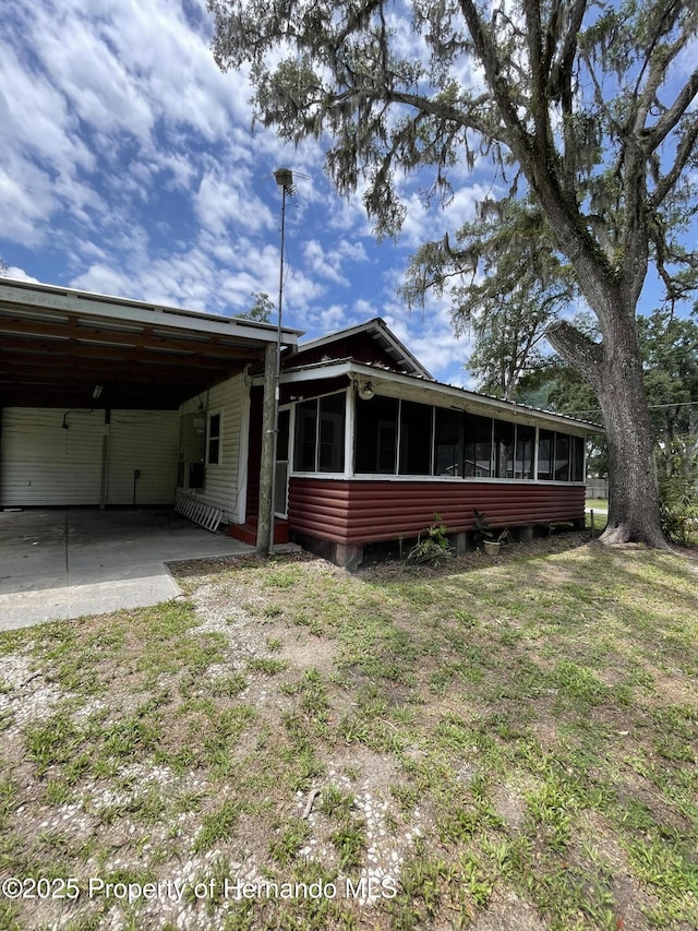 15306 Spokane Rd, Spring Hill Pasco, FL 34610 - back of property with a sunroom and an attached carport