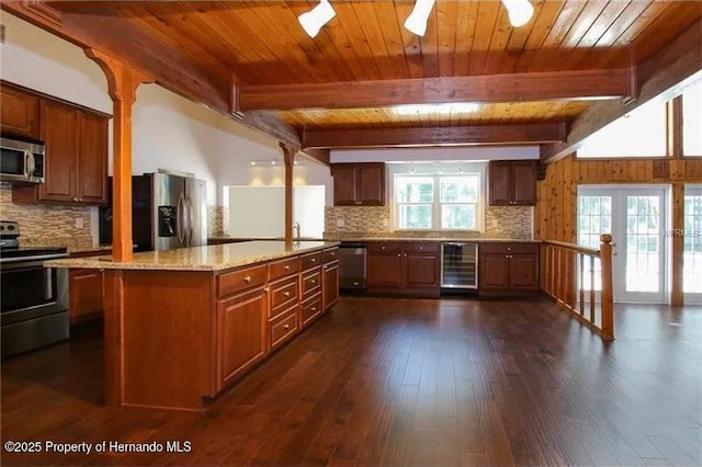 39127 Pretty Pond Rd, Zephyrhills, FL 33540 - kitchen with stainless steel appliances, beverage cooler, tasteful backsplash, wooden ceiling with exposed beams, and light stone counters