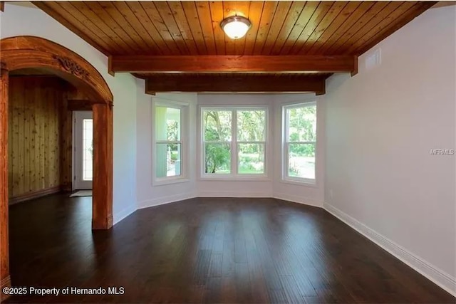 39127 Pretty Pond Rd, Zephyrhills, FL 33540 - unfurnished room with dark wood-style floors, baseboards, wood ceiling with exposed beams, and arched walkways