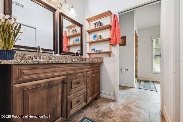 39127 Pretty Pond Rd, Zephyrhills, FL 33540 - bathroom featuring vanity, baseboards, and stone finish flooring