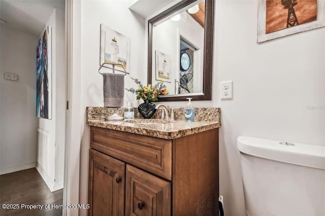 39127 Pretty Pond Rd, Zephyrhills, FL 33540 - bathroom featuring vanity, toilet, wood finished floors, and baseboards