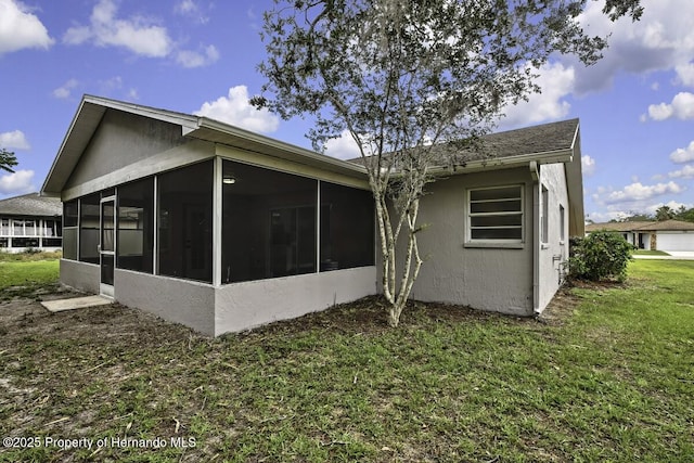 13406 Banyan Rd, Spring Hill, FL 34609 - back of property with a sunroom, stucco siding, and a lawn