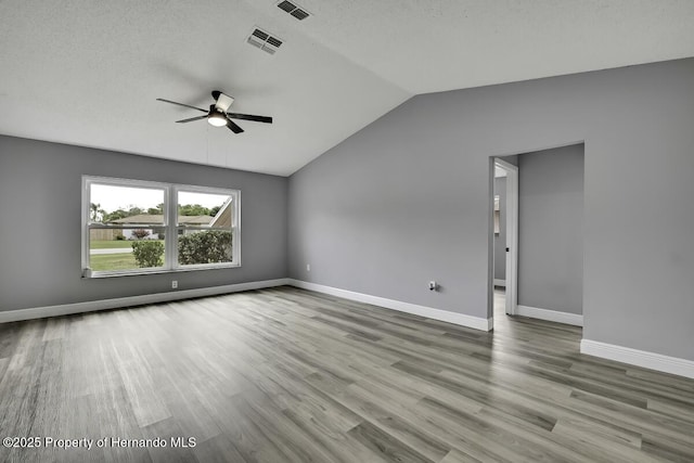 13406 Banyan Rd, Spring Hill, FL 34609 - unfurnished room featuring ceiling fan, wood finished floors, vaulted ceiling, baseboards, and a textured ceiling